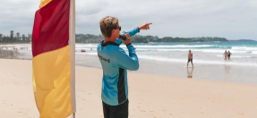 lifeguard on beach with flag and whistle