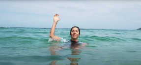 person in water with hand raised