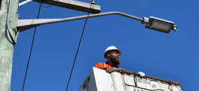 A picture of a worker installing new street smart LED lights