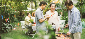 3 people enjoy a barbeque outside