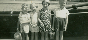 Black and white photograph of four children smiling