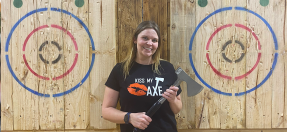 A Kiss My Axe worker in Brookvale holds an axe in front of two targets