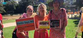 3 people holding signs standing at a 16 days of activism event