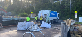 Garbage collectors loading fine fuel bags into a truck