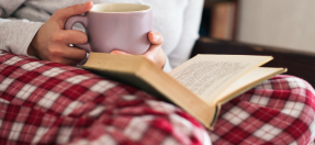 A woman in pyjamas reading a book