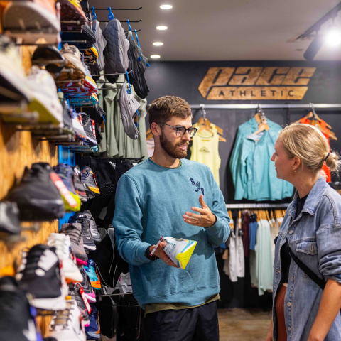 Shop keeper standing at shop Pace Athletic with customer