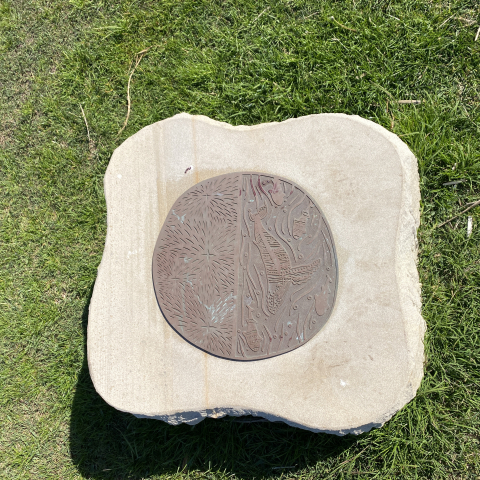 Bronze artwork of whales on top of a sandstone slab