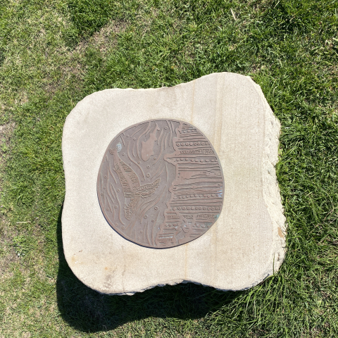 Bronze artwork of whales on top of a sandstone slab