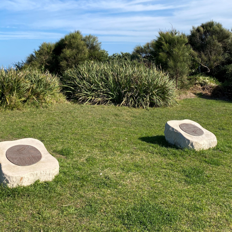 Bronze artwork of whales on top of a sandstone slab